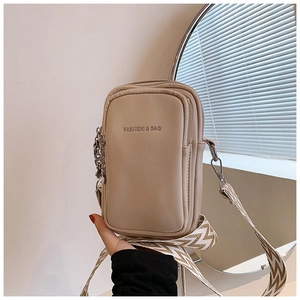 Détail du sac bandoulière en similicuir beige avec sangle large et texte fashion