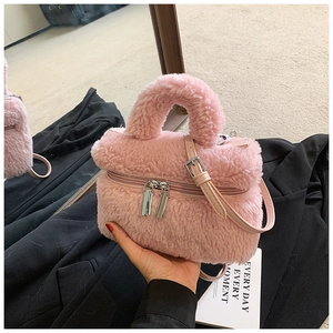 Detail van de kleine roze pluche handtas met dubbele zilveren ritsen en een zacht handvat