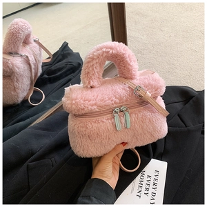 Detail der rosa Plüsch-Umhängetasche mit silbernen Reißverschlüssen und Ledergriffen
