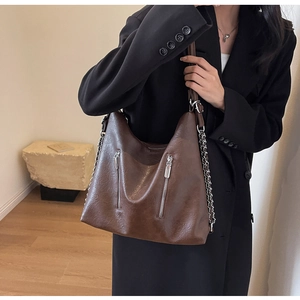 Detail of a dark brown vintage textured faux leather tote bag with silver chain straps