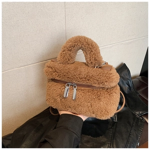 Detail der flauschigen karamellfarbenen Plüschtasche mit silbernen Reißverschlüssen
