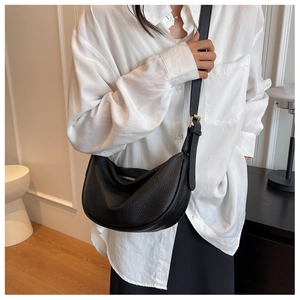 Gros plan détaillé d'un sac hobo en cuir noir avec une boucle en métal doré élégante