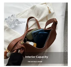 Spacious interior of brown lychee leather crescent bag with gold zipper and zip pocket