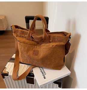 Macro shot of large corduroy tote bag in caramel with leather patch and strap