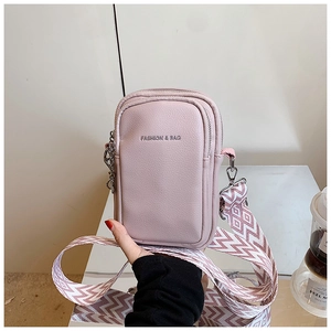 Gros plan d'un sac bandoulière rose en cuir avec large sangle tissée et chaîne argent