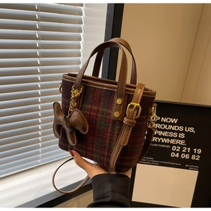 Détail du mini sac cabas en tweed à carreaux avec garniture en cuir brun et dorures
