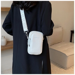 Détail du sac de téléphone en cuir crème avec une large bandoulière géométrique