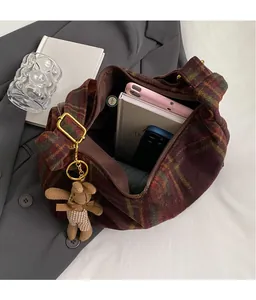 Detail view of plaid wool tote bag interior with bunny pendant and brass hardware