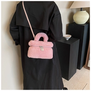 Detail van roze pluche emmertas met ritssluiting en zacht handvat voor dames