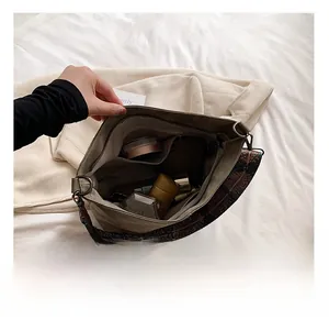 Top-down detail showing large capacity interior of khaki tote bag with wide ethnic strap