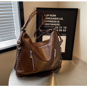 Close-up of dark brown hobo bag with litchi texture leather and metal chain strap
