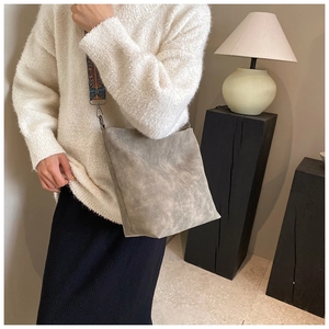 Detail of grey crossbody bucket bag featuring ethnic style patterned wide strap