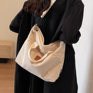 Off-white corduroy tote bag with adjustable shoulder strap and leather logo patch