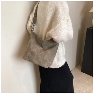 Detail of vintage hobo bag featuring ethnic embroidery strap and retro textured leather