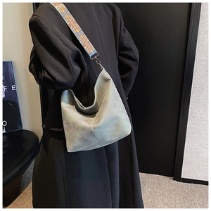 Detail of grey suede hobo bag with a vibrant geometric bohemian wide shoulder strap