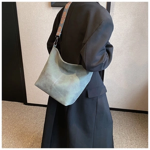 Detail view of vintage grey suede bucket bag with ethnic geometric wide shoulder strap