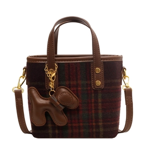 Sac seau en laine écossaise avec finitions cuir et breloque chien sur fond blanc