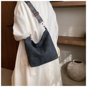 Detail of hobo bag with ethnic geometric wide strap in a cozy interior setting