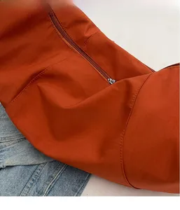Détail du tissu en toile rouge rouille léger avec fermeture éclair et coutures précises