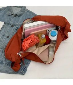 Grand sac bandoulière en toile orange montrant l'espace de rangement pour tablette et parapluie