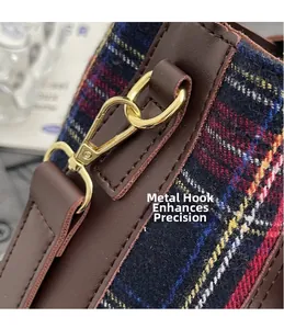 Detail of the golden metal hook on an English vintage plaid wool and brown leather bag