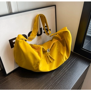 Détail d'un sac demi-lune en nylon jaune vif avec bandoulière réglable et boucles argentées