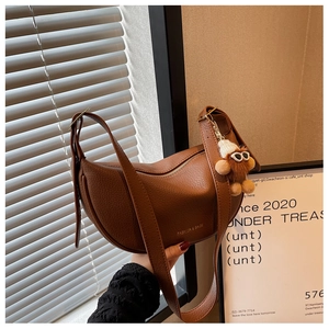 Brown litchi leather saddle bag with fashion logo and plush cartoon doll charm