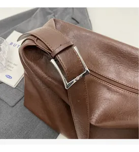 Detail of silver metallic buckle on brown oil wax leather bag with vintage texture
