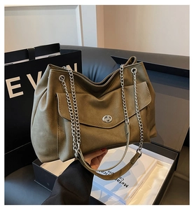 Detail of olive green leather tote bag featuring silver twist lock and chain strap