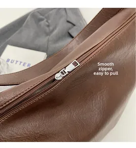 Macro shot of smooth silver zipper detail and lychee textured brown leather on tote bag