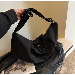 Détail d'un sac bandoulière demi-lune noir en nylon avec large sangle réglable et zip