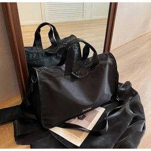 Detail view of a large black nylon commuter pillow bag with adjustable shoulder strap