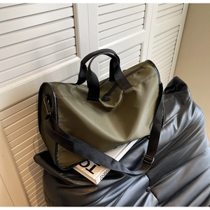 Detail of olive green large capacity travel bag with black straps on luxury background