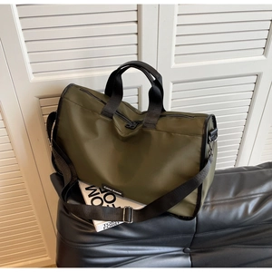 Macro detail of large olive green nylon travel bag with reinforced black handles and straps
