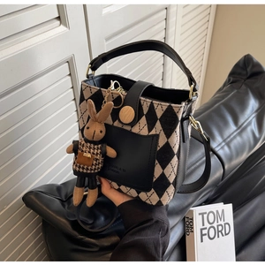 Detail of vintage bucket bag featuring black and beige contrast weaving with rabbit charm