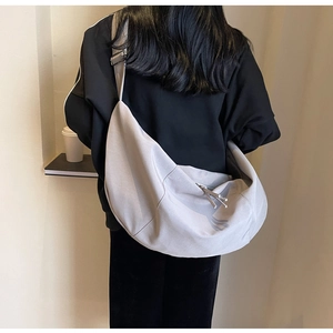 Détail du sac croissant en nylon gris clair avec large bandoulière et coupe décontractée
