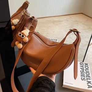 Brown lychee leather half-moon Hobo bag with adjustable strap and plush charm
