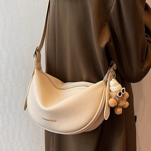 Creamy white crescent saddle bag with litchi texture and a cute teddy bear pendant