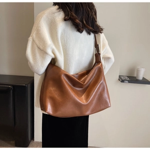 Brown retro hobo bag with adjustable metal buckle shown on shoulder for daily commute
