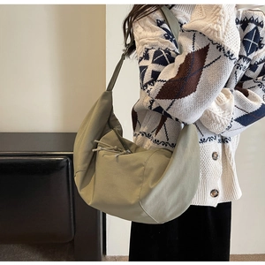 Détail du sac hobo vert avocat montrant la texture en toile épaisse et le nœud du zip