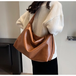 Side view of a brown vintage oversized hobo bag showing its textured PU leather and drape