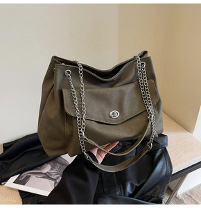 Detail of olive green pebbled leather tote bag with silver chain strap and twist-lock pocket
