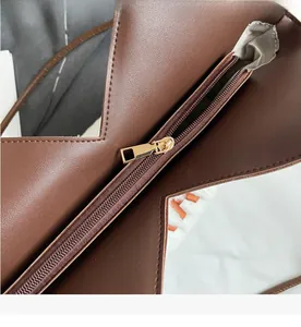 Detail eines glatten Metallreißverschlusses und Fischgrätenfutters an brauner Ledertasche