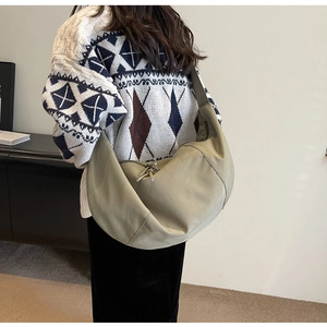 Détail du sac bandoulière demi-lune vert montrant sa grande capacité et son similicuir doux