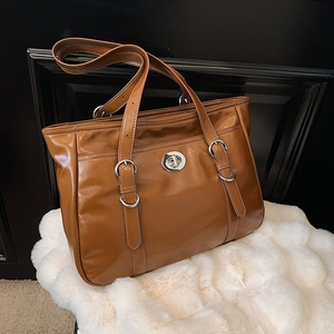 Brown glossy leather tote bag with silver rotary lock and adjustable shoulder straps