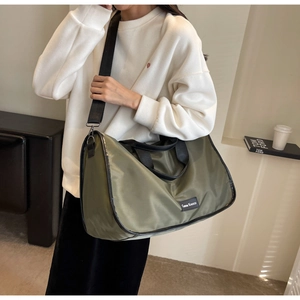 Olive green waterproof nylon tote bag with black handles and branding label detail