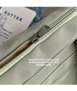 Detail of light green canvas tote showing the polished silver metal zipper hardware