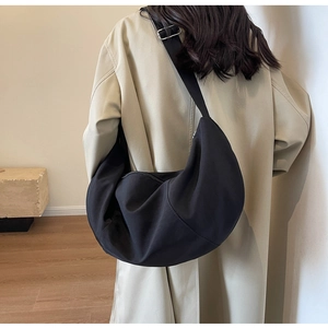 Détail de la bandoulière réglable en toile noire et boucle en métal du sac demi-lune