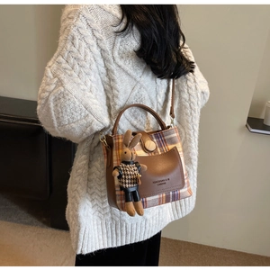 Detail of checkered autumn bucket bag with leather pocket and cute rabbit charm