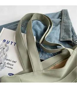 Detail of sage green canvas tote bag featuring secure zipper closure and internal pocket